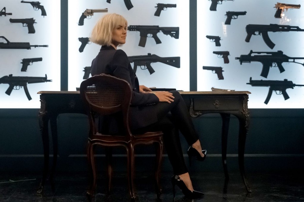 Barbara Kean (Erin Richards) assise dans une salle remplie d'armes