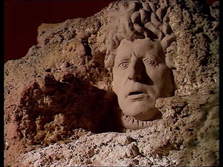 Le visage du Dieu Xoanon gravé dans la roche
