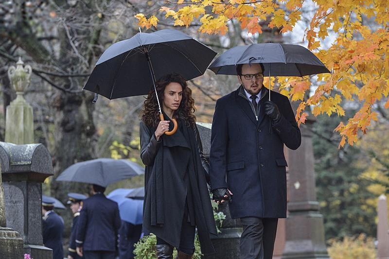 Tess et J.T. sous leur parapluie à l'enterrement