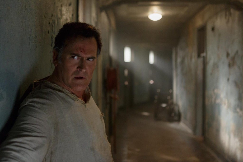 Ash (Bruce Campbell) se faufile dans un couloir de l'asile